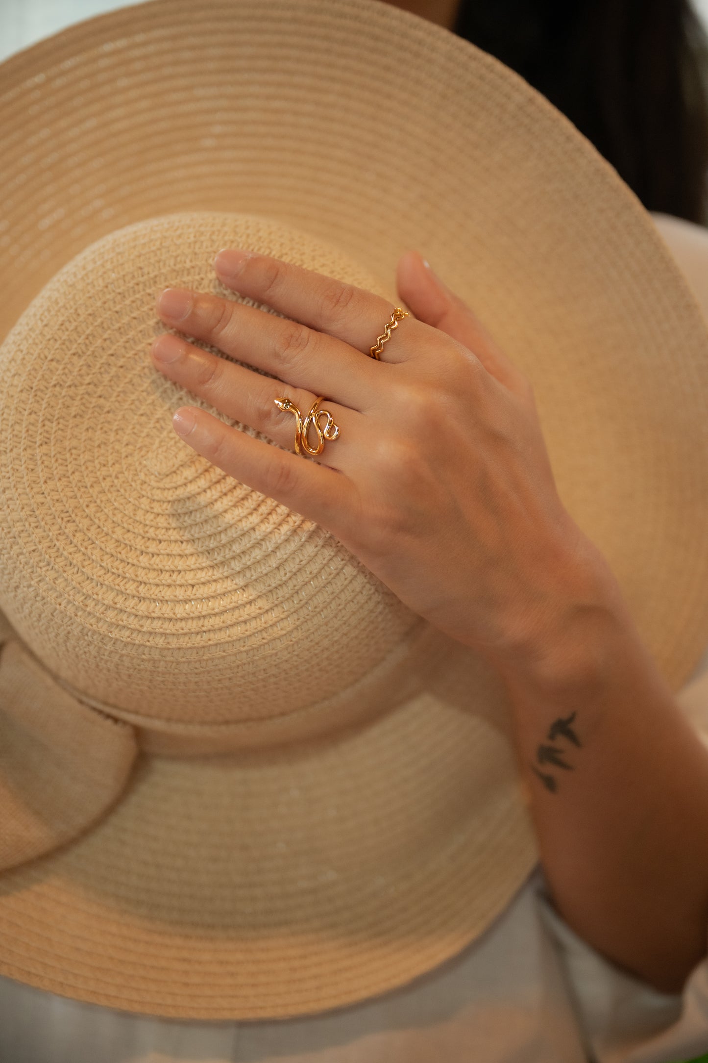 Hand with gold rings on a straw hat