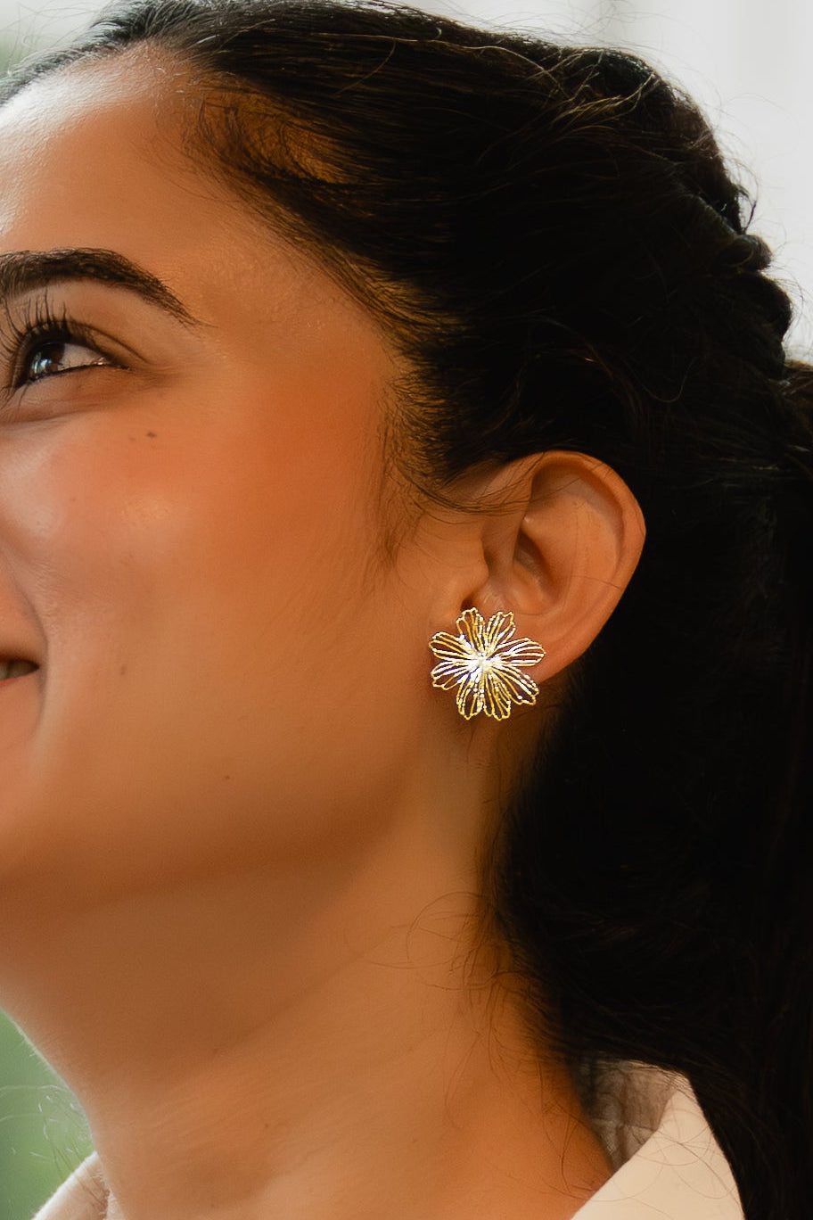 Woman wearing a white shirt and straw hat with a blurred background